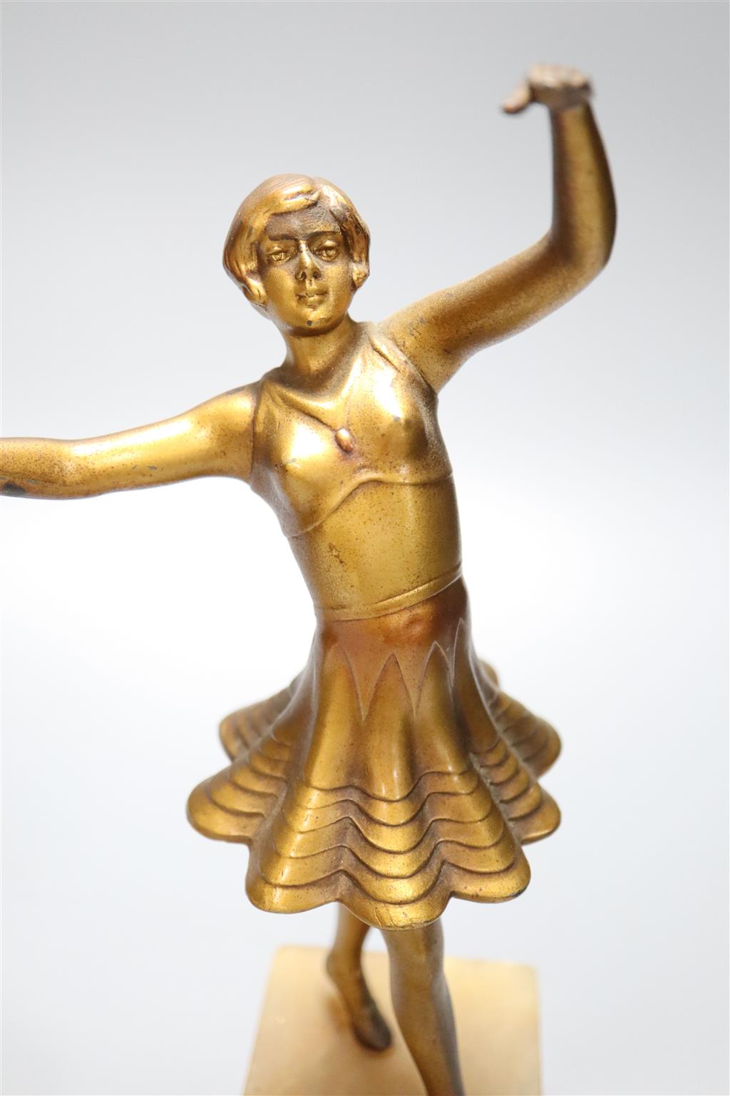 A pair of Art Deco gilt metal figures of young female dancers, on alabaster plinths, 25cm